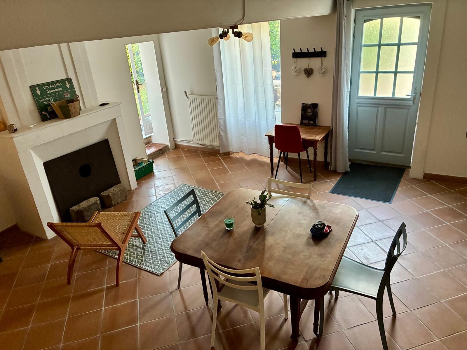 Zona pranzo con tavolo, sedie, camino e vista sull'esterno.