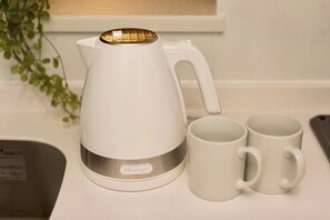A white electric kettle with a gold lid, two white mugs, and a plant on a kitchen counter. - ONESCLarge Twin Room / Sapporo Hokkaidō (Sapporo)