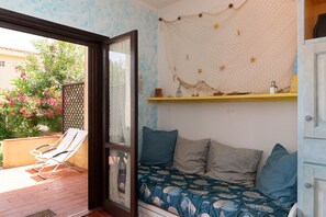 Une pièce avec un lit, une fenêtre, une porte et une vue sur un jardin.