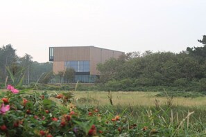 A modern building with a flat roof, large windows, and a wooden facade. - More about the Wadden Sea Doris Frenzel (Cuxhaven)