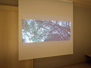 Eine projizierte Leinwand zeigt einen Baum vor blauem Himmel.