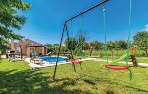 A backyard with a swing set, a swimming pool, and a house. - Stunning home in Pula with private swimming pool, can be inside or outside (Pula)