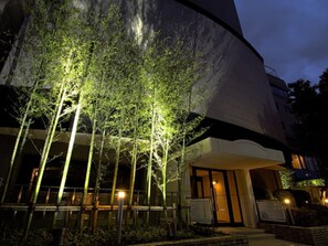 A modern building with a curved facade, a covered entrance, and a well-lit exterior. - HOTEL LiVEMAX Tottori GRANDE (Tottori-shi)