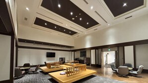 A modern conference room with a wooden table, chairs, and a television screen. - HOTEL LiVEMAX Tottori GRANDE (Tottori)