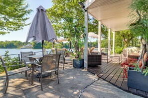 A patio with outdoor furniture, a table, and a covered area overlooking a body of water. - Private Dock & Boat Slip! Belleville Lake Escape (Belleville)