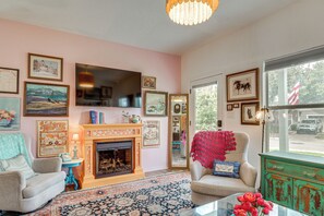 A living room with a fireplace, framed artwork, and a view of the outside. - < 1 Mi to Georgetown Square & SU! Extended Base (Georgetown)