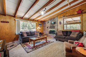 Ein gemütliches Wohnzimmer mit Kamin, Holzbalken und einer Steinwand.