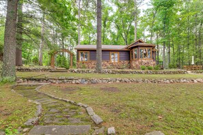 A cabin surrounded by a stone wall and a stone pathway. - Waterfront Tee Lake Cabin: Dock, Fire Pit + More! (Lewiston)