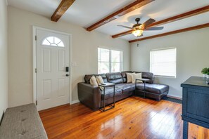A living room with a sectional sofa, wooden flooring, a ceiling fan, and a door with a window. - Walk to Beautiful & Historic Downtown Mount Dora (Mount Dora)