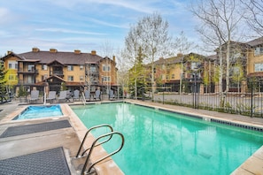 A swimming pool with steps and lounge chairs, surrounded by apartment buildings. - Condo in the Heart of Dtwn Winter Park (Winter Park)
