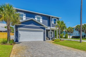 A two-story house with a garage, a driveway, and a lawn with palm trees. - Close to Beach! Miramar Beach Haven w/ Pool Access (Miramar Beach)