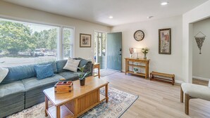 Un salon comprenant un canapé, une table basse et une porte donnant sur un balcon.