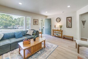 A living room with a sofa, coffee table, and a door leading to a balcony.