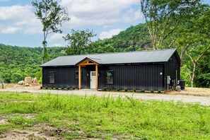 Un petit bâtiment en bois sombre, doté d’un toit en pente, d’un porche à l’avant et d’une porte.