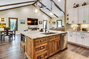A spacious kitchen with a large island, wooden cabinets, and a farmhouse ceiling. - Roxboro Lake Family Retreat and Spa (Prospect Hill)