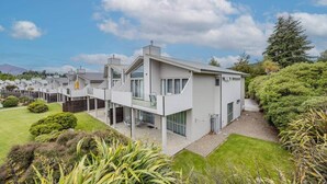 A modern residential building with a flat roof, large windows, and a covered outdoor area. - Mountain Four-Guest with Views (Wanaka)