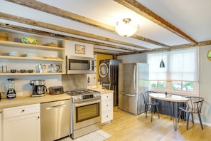 A kitchen with a stove, oven, microwave, and refrigerator. There is a dining table with chairs and a window with blinds. - Historic South Lee Apt 2 Mi to Main Street (South Lee)
