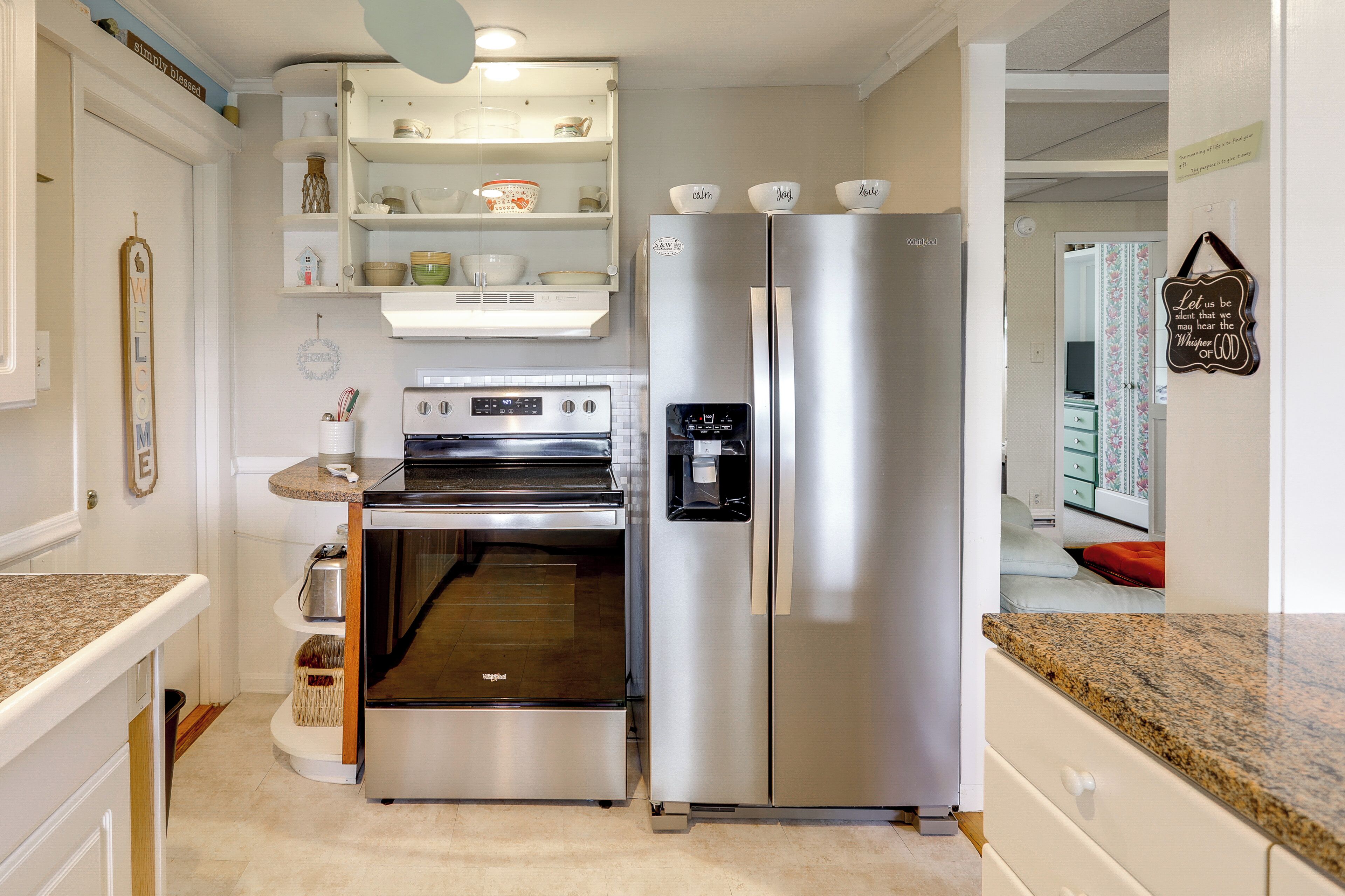 A kitchen with a stainless steel refrigerator, oven, and granite countertops.