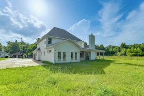 A two-story house with a covered porch and a chimney. - On Several Acres! Luxury Home in Prairieville (Prairieville)