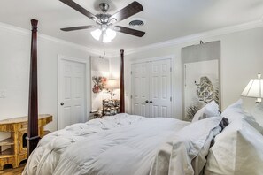 Ein Schlafzimmer mit einem Bett, einem Deckenventilator, einer Katzenleiter und einer Wandmalerei mit Tigern.