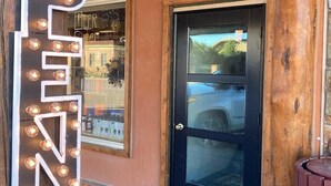 A wooden building with a black door and a sign that reads 'OPEN'. - Jackalope Loft in Downtown Custer #2 (Custer)