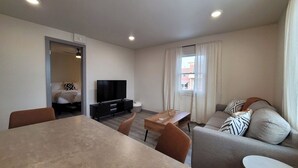 A modern living room with a dining table, sofa, and TV. - Jackalope Loft in Downtown Custer #2 (Custer)