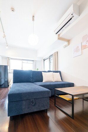 En moderne stue med en modulsofa, et sofabord og en aircondition.