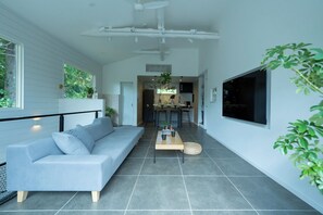 A modern living room with a sofa, a coffee table, and a TV mounted on the wall. - Dogfriendly vacation rental Room only Maximum / Ito City Shizuoka (Ito City)