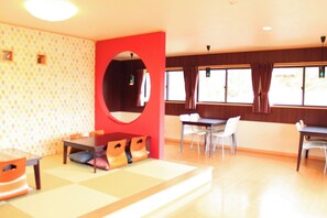 Una habitación con una mesa de comedor, sillas, un sofá y un espejo grande.