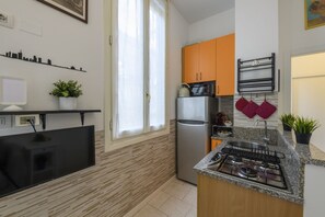 Eine moderne Küche mit Flachbildfernseher, Kühlschrank, Mikrowelle und Gasherd.