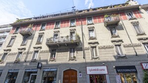 Ein mehrstöckiges Gebäude mit Geschäften im Erdgeschoss, darunter 'igiornidi carta' und 'VESTOPAZZO'.
