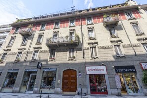 Ein mehrstöckiges Gebäude mit Geschäften im Erdgeschoss, darunter 'igiornidi carta' und 'VESTOPAZZO'.
