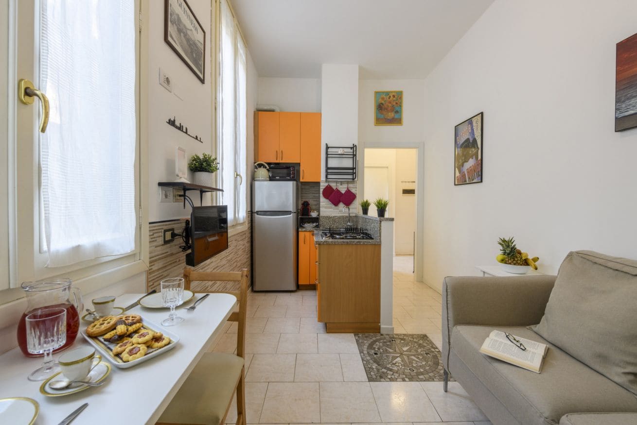 A compact living space with a kitchenette, dining area, and a sofa.