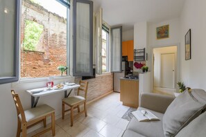 Ein kompakter Wohnbereich mit Essbereich, Küchenzeile und Sofa.