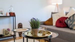 A modern living room with a round coffee table, a potted plant, and a lamp.