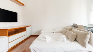 Een hotelkamer met een bed, een televisie, een houten bureau en een stoel.