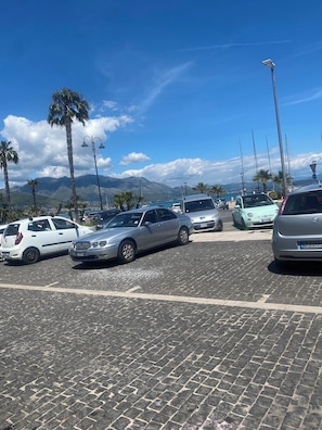 A parking lot with cars, palm trees, and a mountainous backdrop. - Blue House: A beautiful and charming little house in the neighborhoods along Via dell'Indipendenza (Gaeta)