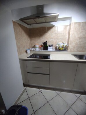 A kitchen with a stove, sink, cabinets, and a tiled backsplash. - Blue House: A beautiful and charming little house in the neighborhoods along Via dell'Indipendenza (Gaeta)