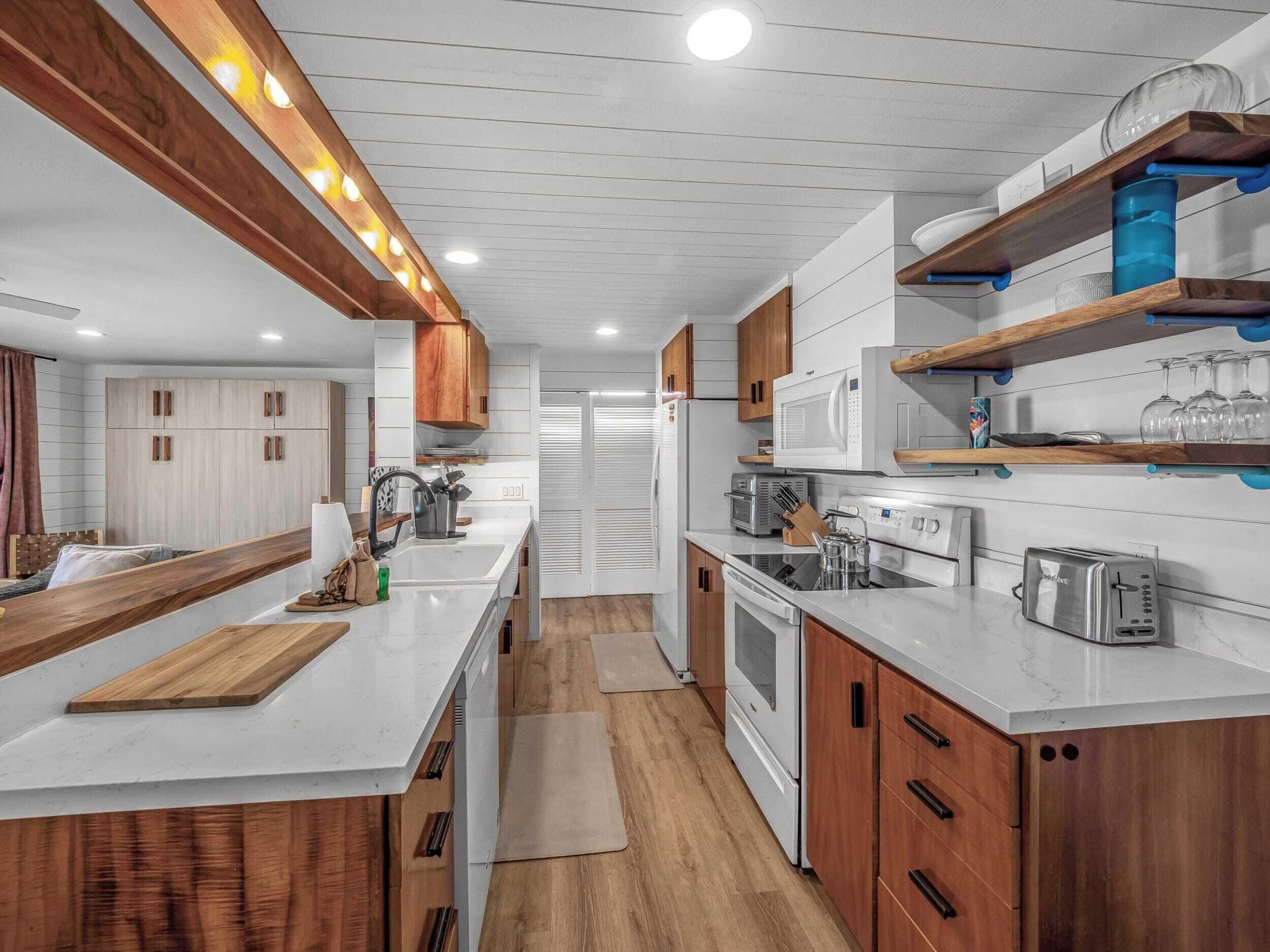 A modern kitchen with white cabinetry, wooden accents, and built-in appliances.