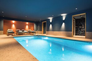 A swimming pool area with lounge chairs and a glass-enclosed spa. - Hotel le Saint Roch (COURCHEVEL)