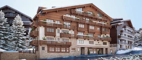 A multi-story hotel with balconies, a stone facade, and snow-covered surroundings.