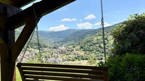 A wooden bench under a shelter with a view of a valley and mountains. - The Black Stag: Finnish sauna, mountain view, sleeps 8 (La Bresse)