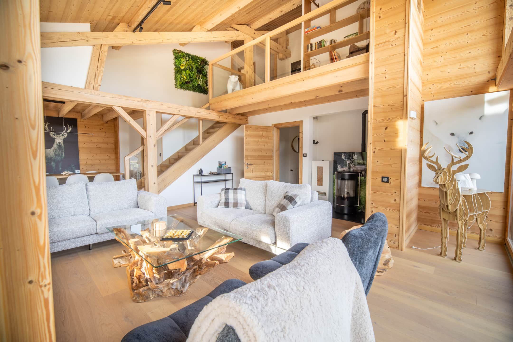 Un espacio habitable amplio con interior de madera, una mesa de centro de vidrio y un sofá.