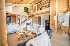 A spacious living area with a wooden interior, a glass coffee table, and a sofa. - The Black Stag: Finnish sauna, mountain view, sleeps 8 (La Bresse)