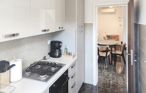 Eine moderne Küche mit Gasherd, Kaffeemaschine und Schränken.