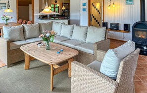A cozy living room with a sofa, a coffee table, wicker chairs, a fireplace, and a kitchen in the background. - Gorgeous home in Storvorde with WiFi (Storvorde)