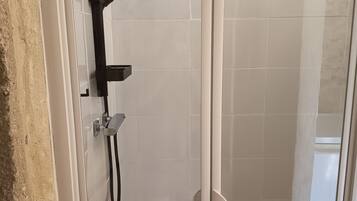 Een douche, handdoeken, toiletpapier