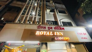Un letrero de hotel con el nombre 'ROYAL INN LODGING' y un cartel en un idioma local.