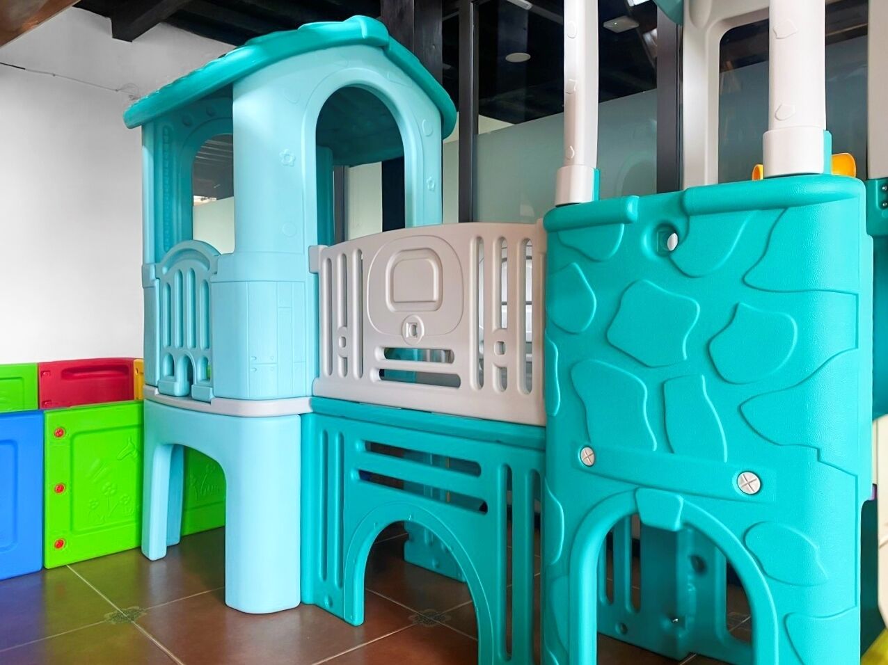 A children's play area with a climbing structure and storage units.