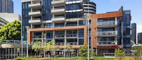 A multi-story building with balconies, a courtyard with seating, and a restaurant with outdoor seating.